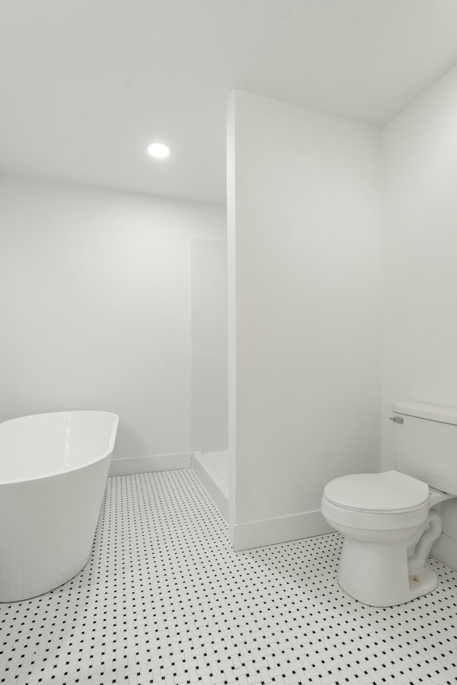 full bathroom featuring baseboards, toilet, recessed lighting, a walk in shower, and a freestanding bath