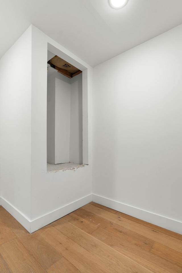 spare room featuring light wood-style flooring and baseboards