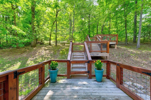 deck featuring stairs and a wooded view