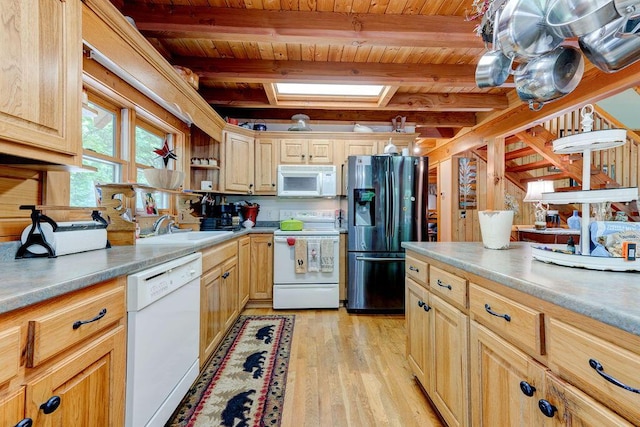 kitchen featuring white appliances, light wood-style floors, wood ceiling, a sink, and a skylight