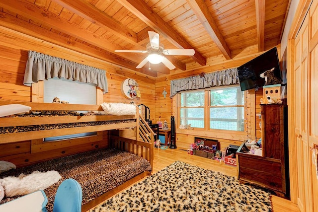 bedroom featuring wooden walls, beamed ceiling, wooden ceiling, and wood finished floors