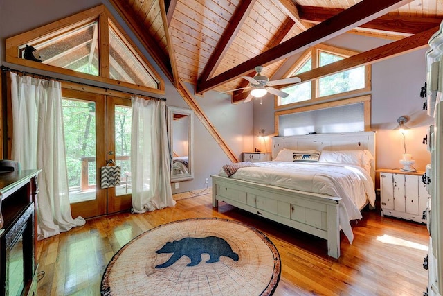 bedroom with multiple windows, beamed ceiling, french doors, and hardwood / wood-style flooring