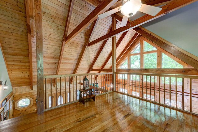 additional living space with vaulted ceiling with beams, wood ceiling, ceiling fan, and wood-type flooring