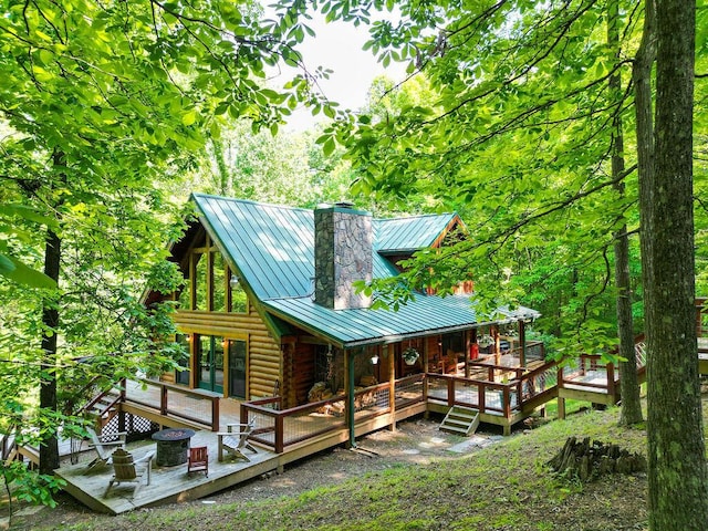 rear view of house featuring a standing seam roof, french doors, metal roof, a chimney, and log exterior