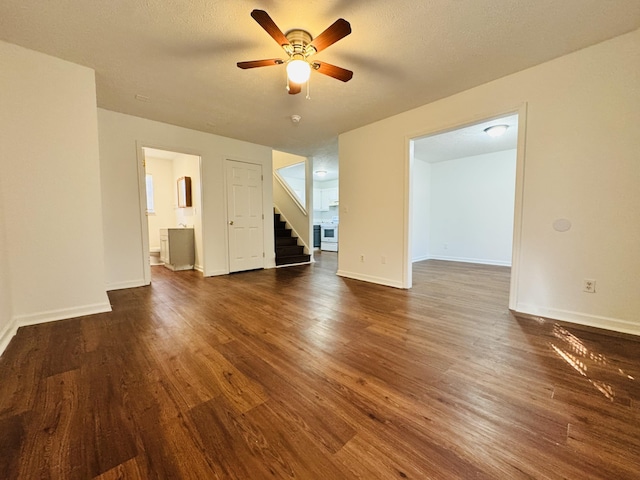 unfurnished living room with dark wood-style flooring, a ceiling fan, baseboards, and stairway