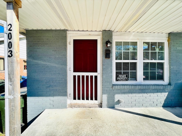 doorway to property featuring brick siding