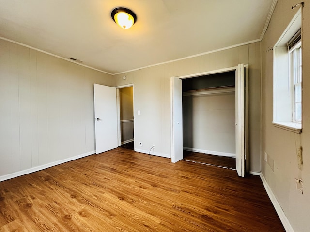unfurnished bedroom featuring crown molding, visible vents, and wood finished floors