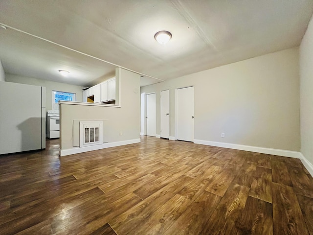 unfurnished living room with baseboards and wood finished floors