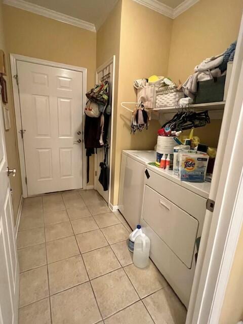 laundry area featuring washer and clothes dryer, light tile patterned floors, ornamental molding, and laundry area