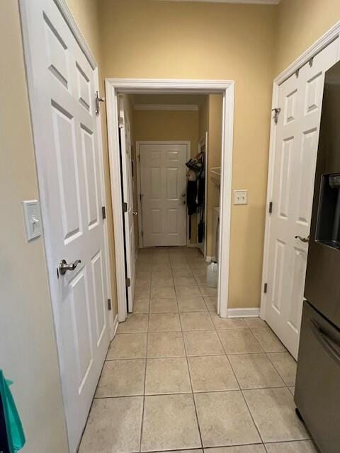 corridor with baseboards and light tile patterned floors