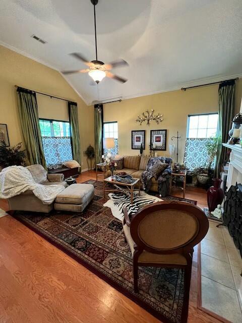 living room featuring visible vents, ceiling fan, lofted ceiling, and plenty of natural light
