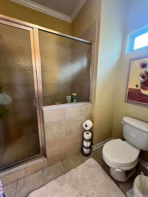 full bath with a shower stall, crown molding, baseboards, toilet, and tile patterned floors