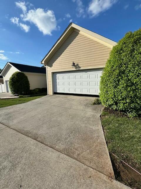view of property exterior with concrete driveway