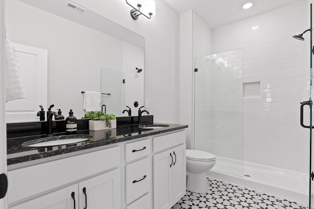 full bath featuring a stall shower, visible vents, a sink, and double vanity
