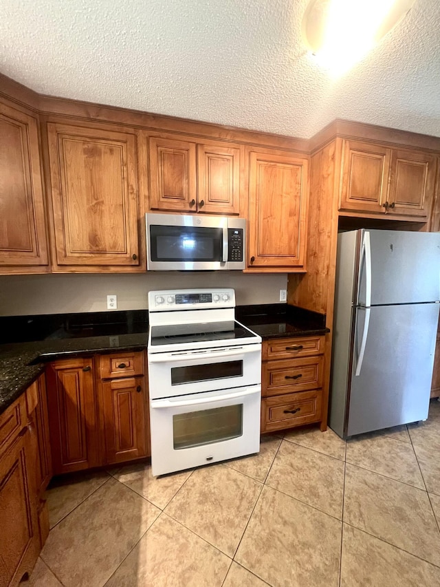 kitchen with dark countertops, brown cabinets, and stainless steel appliances