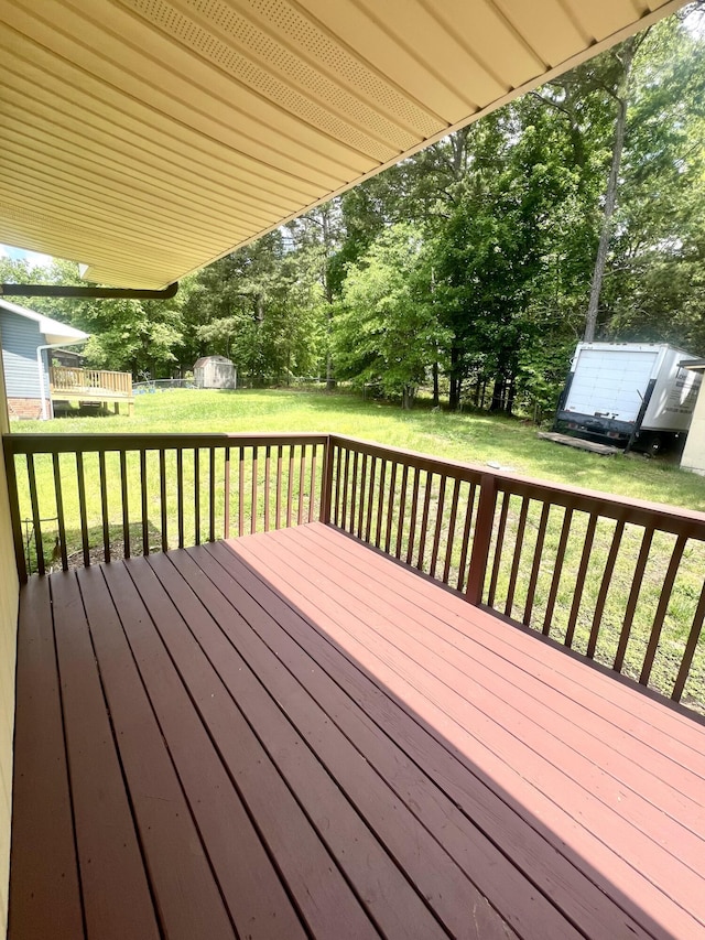 deck featuring a shed, an outbuilding, and a yard
