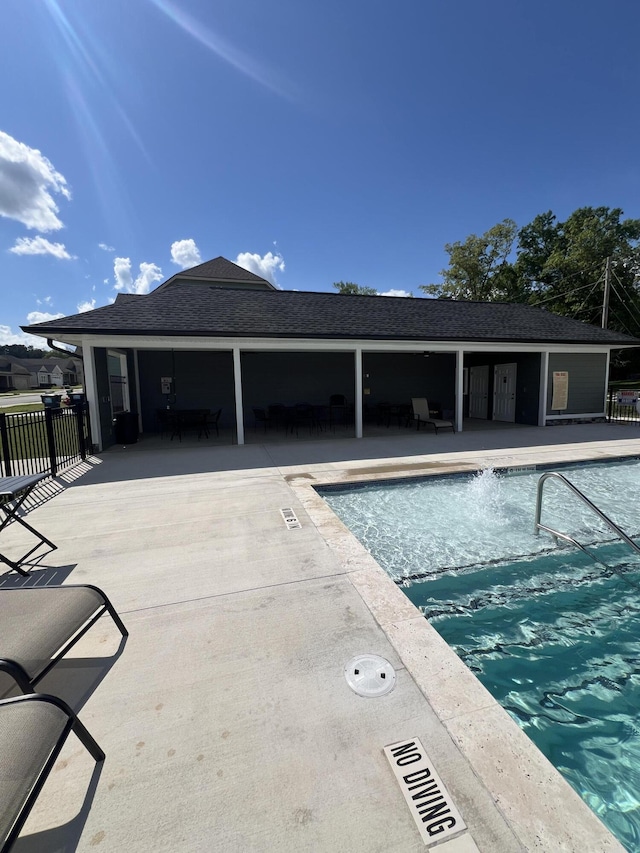 community pool with a patio and fence
