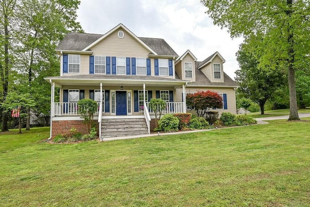 colonial inspired home with covered porch, a shingled roof, and a front lawn