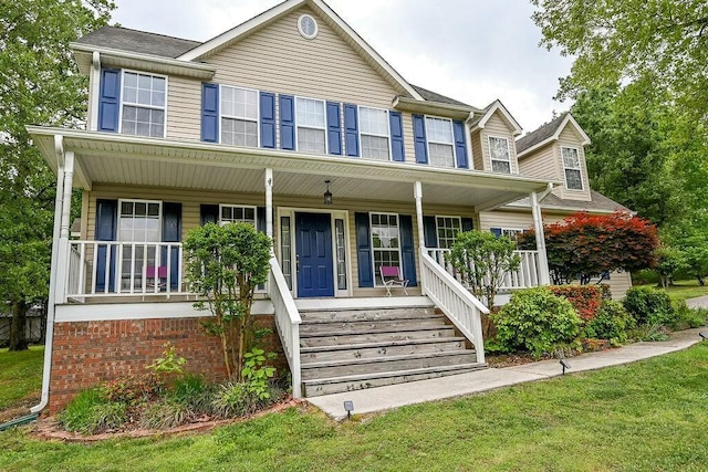 colonial inspired home featuring a front yard and covered porch