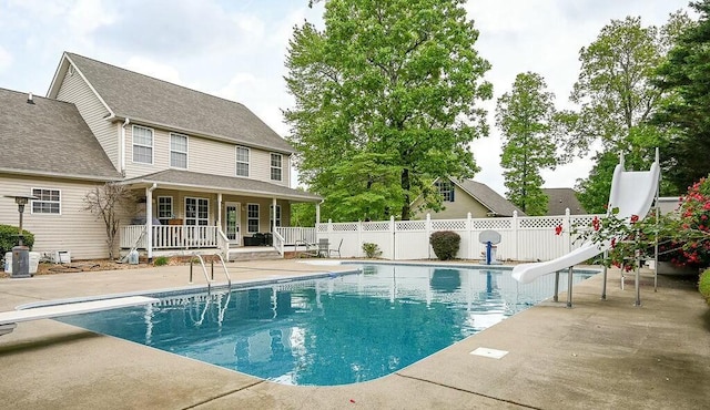 view of swimming pool with a diving board, fence, a fenced in pool, a water slide, and a patio area