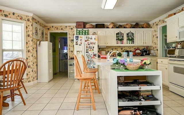 kitchen with wallpapered walls, ornamental molding, white appliances, and light tile patterned floors