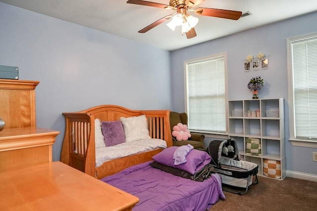 carpeted bedroom with baseboards, ceiling fan, and multiple windows
