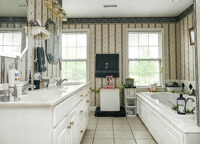 bathroom featuring wallpapered walls, a garden tub, tile patterned flooring, and a sink
