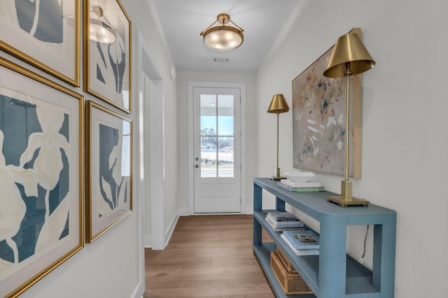 doorway to outside featuring visible vents, wood finished floors, and baseboards