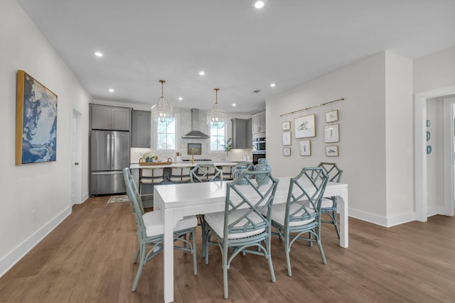 dining area featuring baseboards, recessed lighting, and wood finished floors
