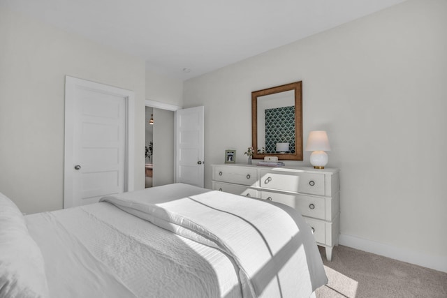 bedroom featuring light colored carpet and baseboards