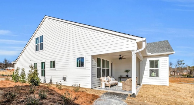 rear view of property featuring roof with shingles, a ceiling fan, and a patio area