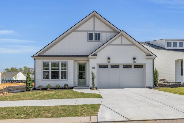 modern farmhouse with board and batten siding, a front lawn, concrete driveway, and an attached garage