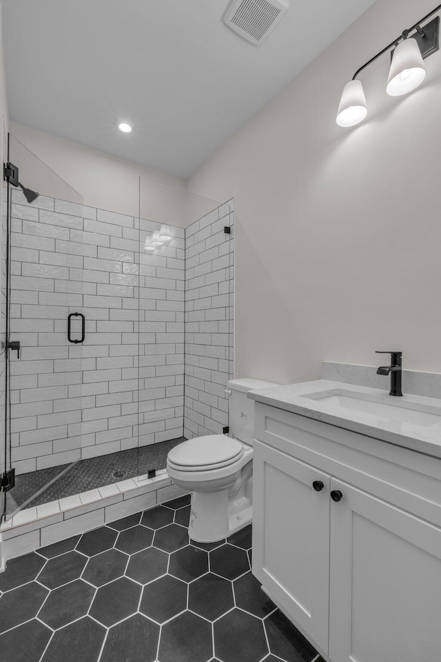 bathroom with recessed lighting, toilet, vanity, visible vents, and a stall shower
