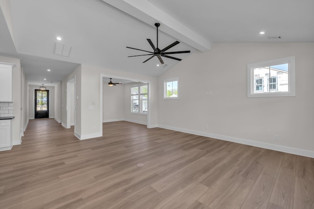 unfurnished living room featuring light wood-style flooring, visible vents, ceiling fan, lofted ceiling with beams, and baseboards