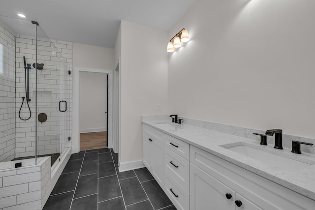 full bathroom with tile patterned flooring, a sink, a shower stall, and double vanity