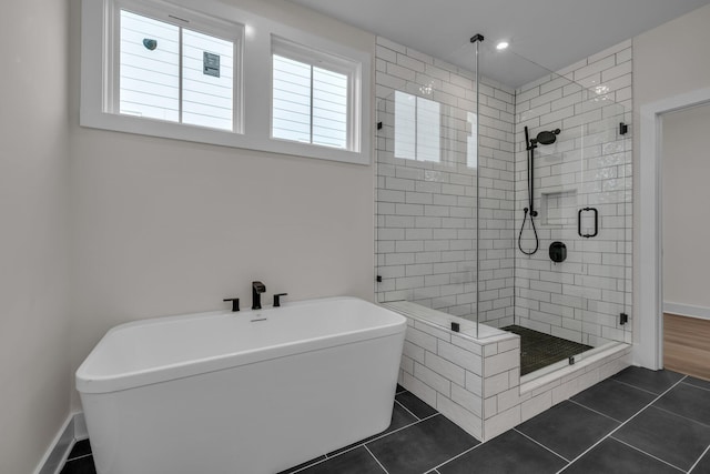 bathroom with a stall shower, tile patterned flooring, and a soaking tub