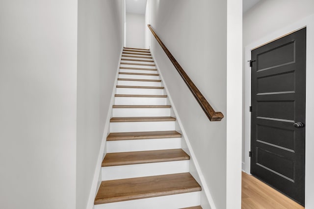 stairway with baseboards and wood finished floors