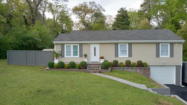 ranch-style house featuring roof with shingles, an attached garage, and a front lawn