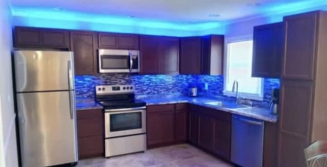 kitchen featuring a sink, appliances with stainless steel finishes, and tasteful backsplash