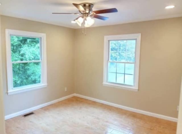 empty room with baseboards, a ceiling fan, and visible vents