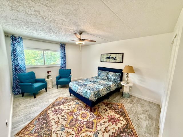 bedroom featuring a textured ceiling, wood finished floors, and baseboards