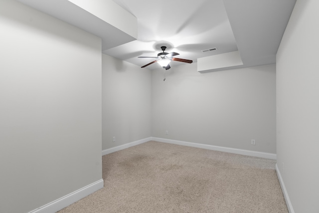carpeted empty room featuring ceiling fan, visible vents, and baseboards