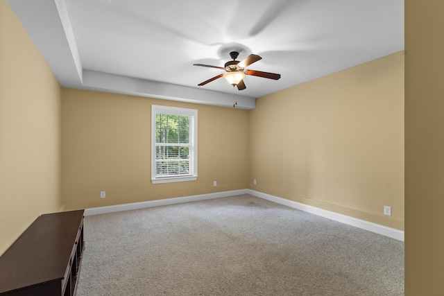 carpeted empty room with a ceiling fan and baseboards
