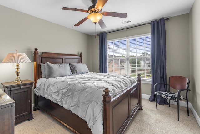 bedroom with baseboards, a ceiling fan, visible vents, and light colored carpet