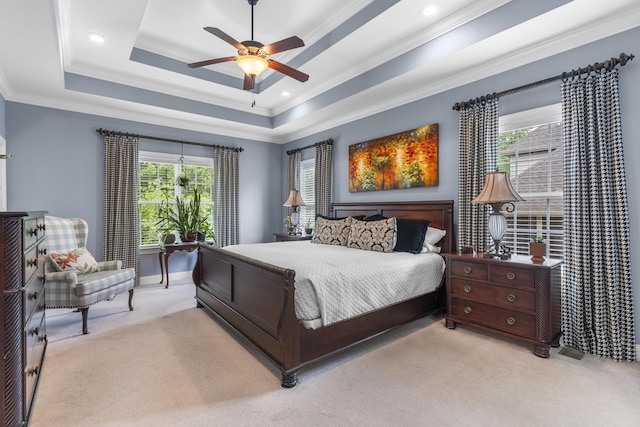 carpeted bedroom featuring baseboards, a tray ceiling, ornamental molding, and ceiling fan