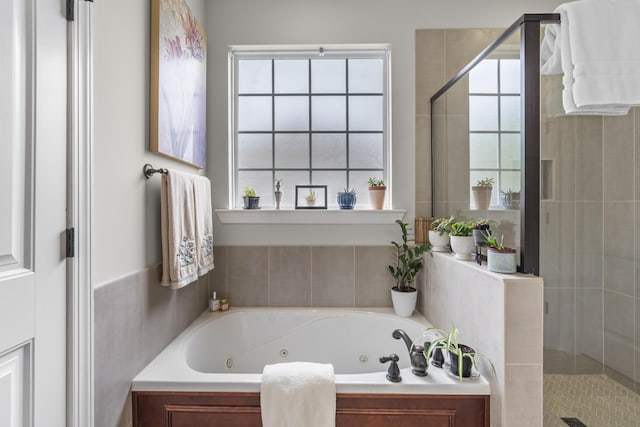 bathroom with a jetted tub and a stall shower