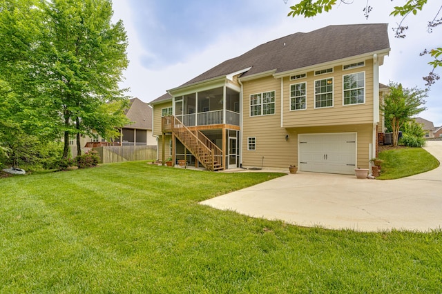 rear view of property featuring fence, an attached garage, a sunroom, stairway, and driveway