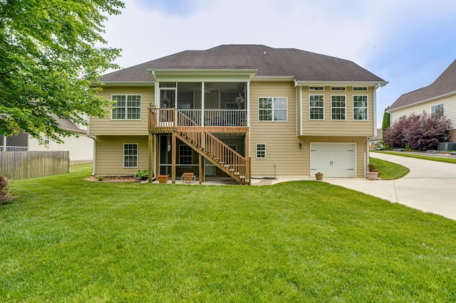 rear view of property featuring stairs, an attached garage, a sunroom, concrete driveway, and a yard