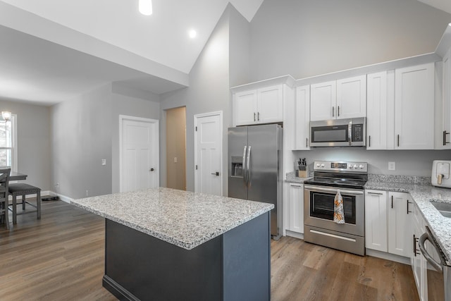 485 Woodland Dr, Jasper, TN 37347 - kitchen featuring light stone counters, high vaulted ceiling, stainless steel appliances, white cabinetry, and wood finished floors