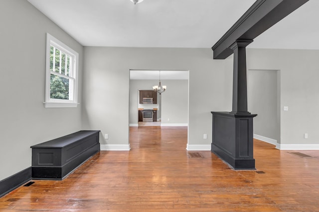 2211 Kirby Ave, Chattanooga, TN 37404 - unfurnished living room with hardwood / wood-style floors, a chandelier, and ornate columns